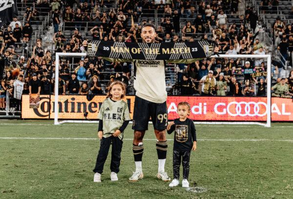Los Angeles FC forward Denis Bouanga (99) pose with his children after the match after receiving the Man of the Match award from a hat-trick performance against the Minnesota United at BMO Stadium in Los Angeles, on Oct 4, 2023. (Courtesy of Los Angeles FC via The Epoch Times)