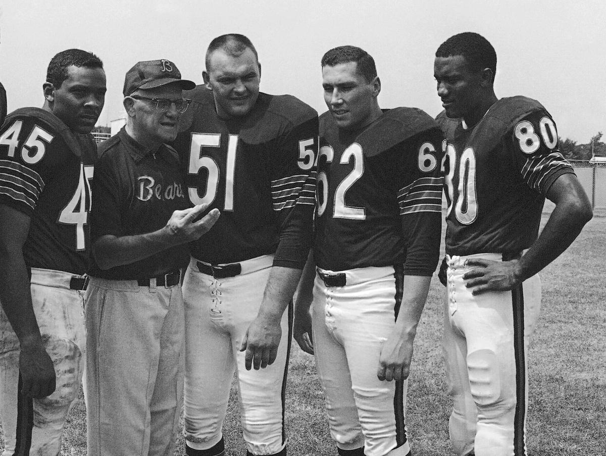 Chicago Bears coach George Halas discusses the upcoming season with four of his second-year men at training camp in July 1966 at St. Joseph's College in Rensselaer, Ind. With Halas are Dick Gordon (45), Dick Butkus (51), Mike Reilly (62), and Jimmy Jones (80). (AP Photo, File)