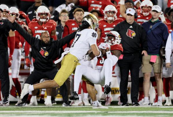 Quincy Riley (3) of Louisville Cardinals intercepts a pass against the Notre Dame Fighting Irish with Head Coach Jeff Brohm overlooking from behind at L&N Stadium in Louisville, Ky., on Oct 7, 2023 (Andy Lyons/Getty Images)