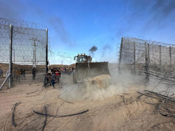 Hamas terrorists break into the Israeli side of Israel-Gaza border fence after gunmen infiltrated areas of southern Israel, Oct. 7, 2023. (Mohammed Fayq Abu Mostafa/Reuters)