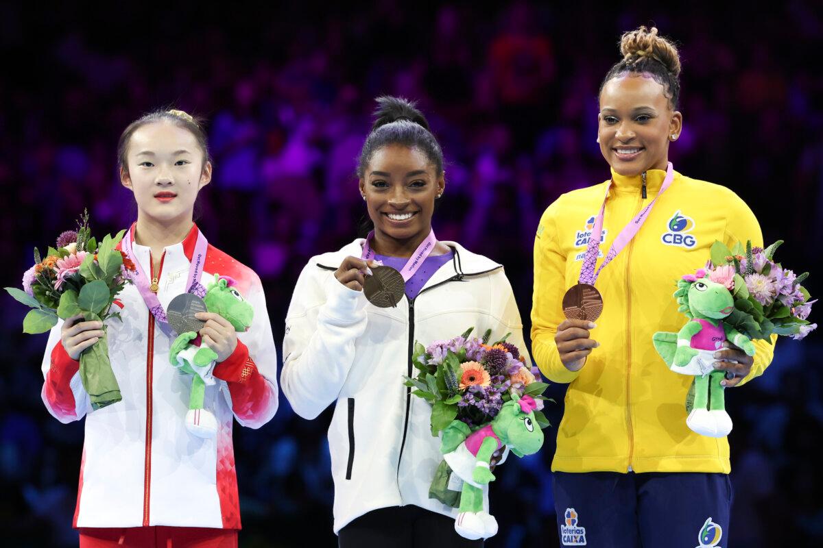 United States' Simone Biles, center and gold medal, China's Zhou Yaqin, left and silver medal, and Brazil's Rebeca Andrade, right and bronze medal, pose on the podium of the beam during the apparatus finals at the Artistic Gymnastics World Championships in Antwerp, Belgium, on Oct. 8, 2023. (Geert vanden Wijngaert/AP Photo)