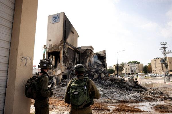 Israeli soldiers look at the remains of a police station that was the site of a battle following a mass infiltration by Hamas gunmen from the Gaza Strip, in Sderot, Israel, on Oct. 8, 2023. (Reuters/Ronen Zvulun)
