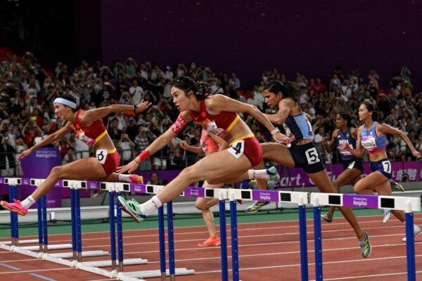 China's Lin Yuwei (L) and China's Wu Yanni (C) competes in the women's 100m hurdles final athletics event during the 2022 Asian Games in Hangzhou in China's eastern Zhejiang province on Oct. 1, 2023. (William West/AFP via Getty Images)