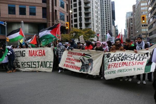Pro-Palestine protesters were seen holding banners as they marched along Bay Street in downtown Toronto on Oct. 9, 2023. (Andrew Chen/The Epoch Times)