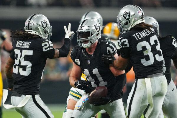 Robert Spillane (41) of the Las Vegas Raiders celebrates with teammates after intercepting the ball during the fourth quarter against the Green Bay Packers at Allegiant Stadium in Las Vegas on Oct. 9, 2023. (Chris Unger/Getty Images)