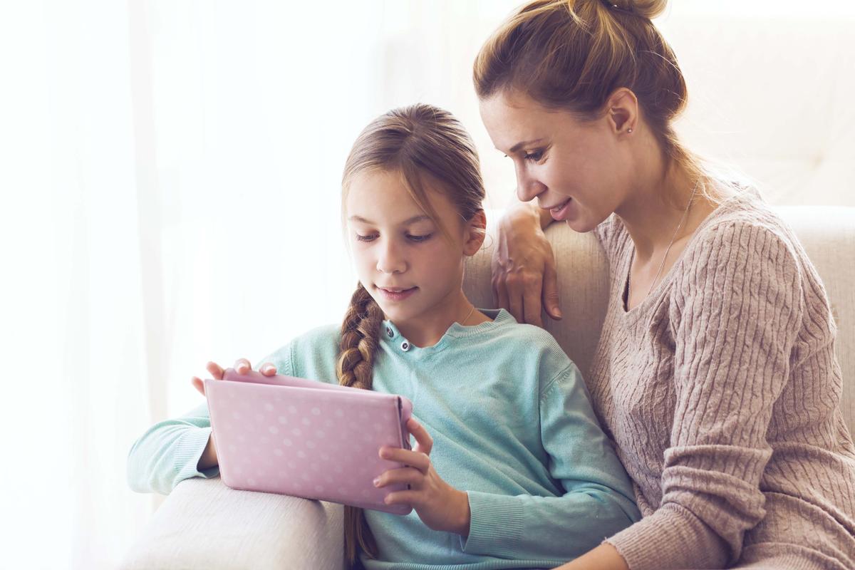 A mom with her young daughter using a tablet. (Illustration - Alena Ozerova/Shutterstock)