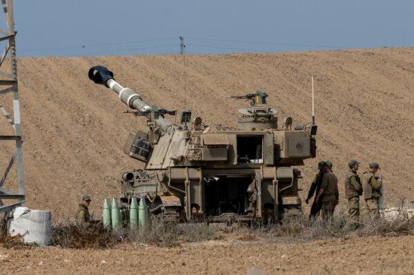 IDF artillery soldiers prepare around their armored vehicles in Netivot, Israel, on Oct. 10, 2023. (Alexi J. Rosenfeld/Getty Images)