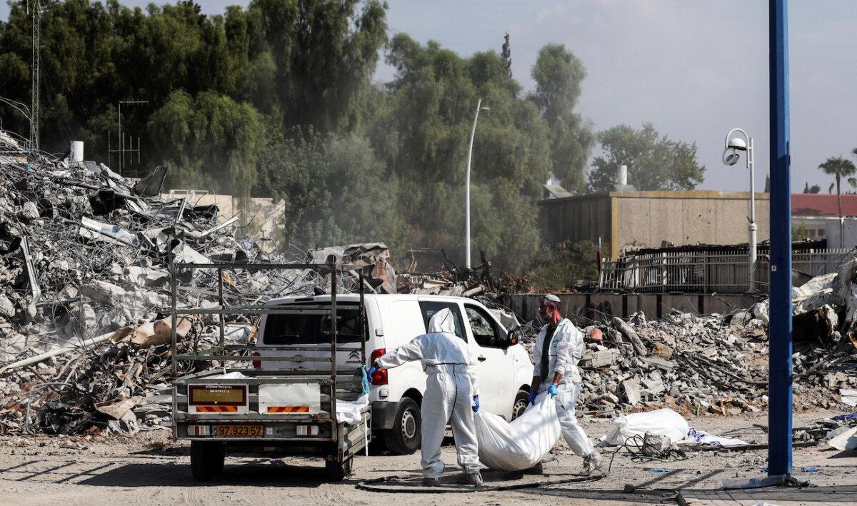 Israeli rescue workers work to remove dead bodies from near a destroyed police station that was the site of a battle following a mass infiltration by Hamas terrorists from the Gaza Strip, in Sderot, Israel, on Oct. 11, 2023. (Violeta Santos Moura/Reuters)