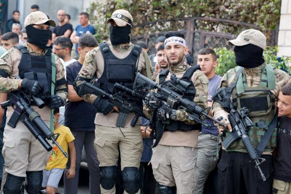 Gunmen stand as mourners attend the funeral of two Palestinians who were killed in clashes with Israeli forces, near Jenin in the Israeli-occupied West Bank on Oct. 11, 2023. (Reuters/Raneen sawafta)