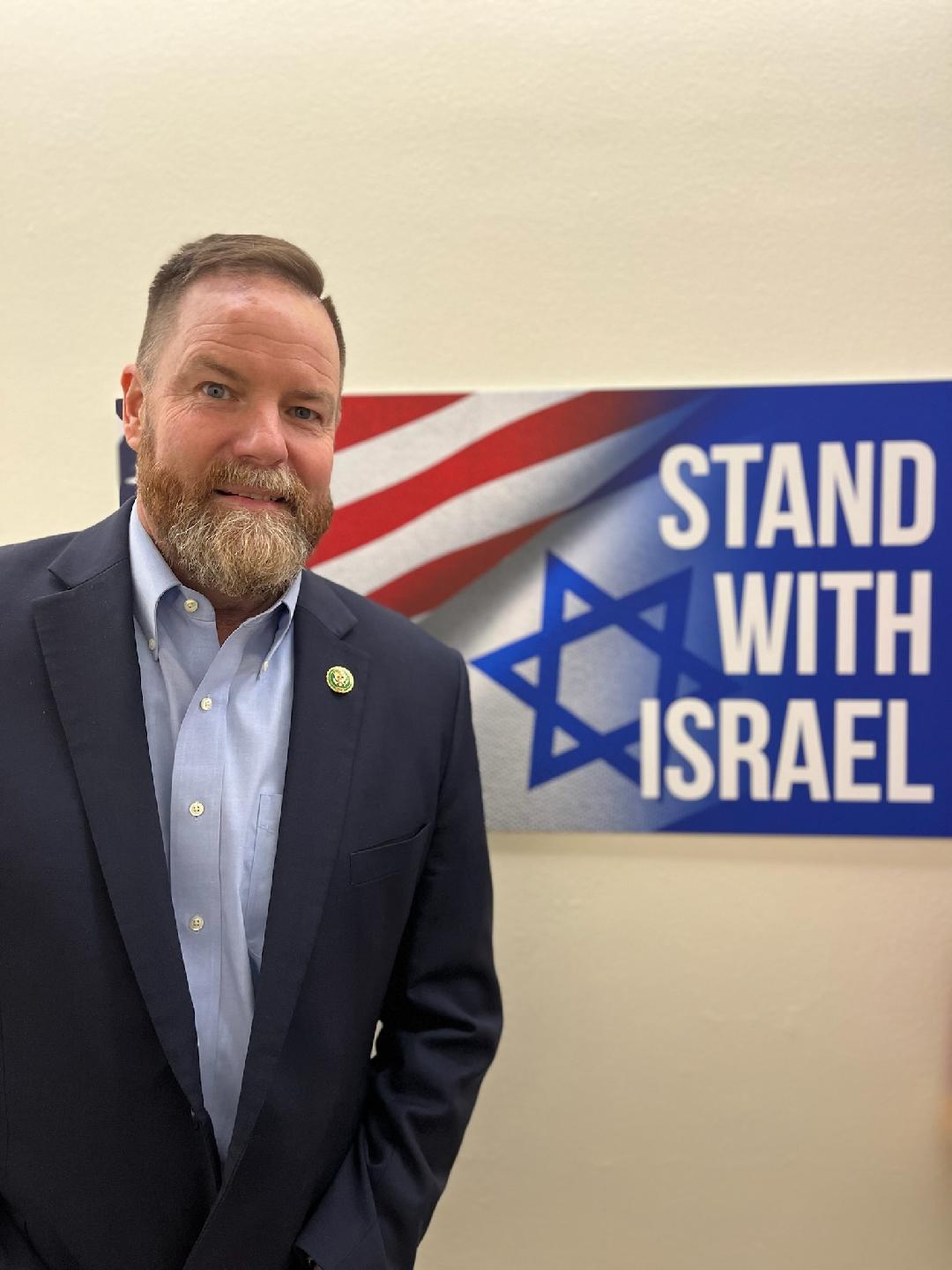 U.S. Congressman (R-Fla.) Aaron Bean poses in front of a "Stand with Israel" sign. (Courtesy of Rep. Aaron Bean)