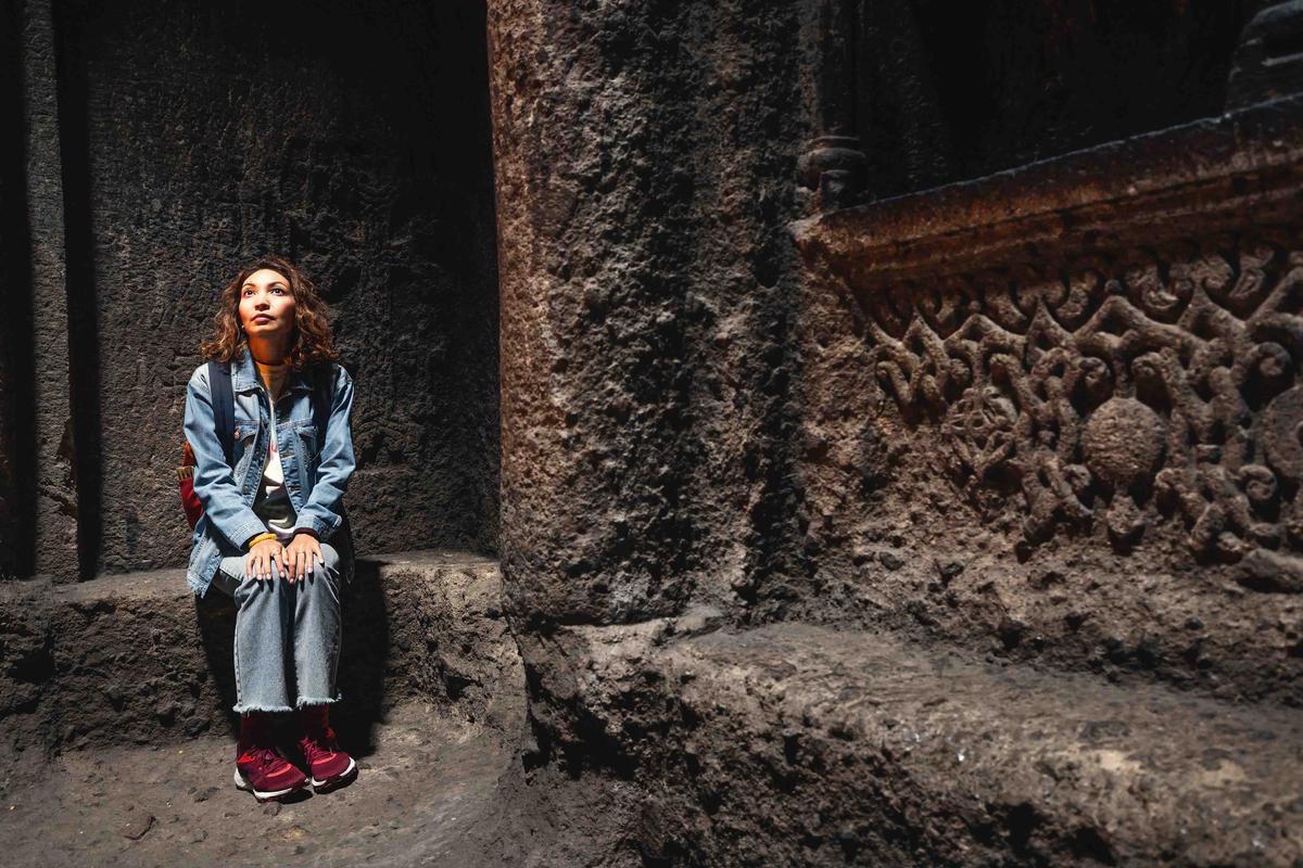 A female traveler sits in the interior of the main church in Geghard Monastery. (Davit Mohrabyan/Shutterstock)