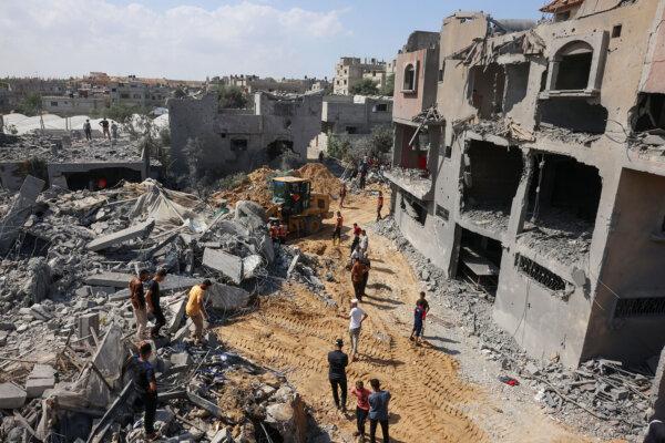 Palestinian rescuers search the rubble of destroyed buildings. ((Said Khatib/AFP via Getty Images)