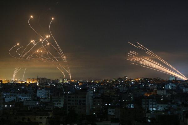 The Israeli Iron Dome missile defense system (L) intercepts rockets (R) fired by Hamas toward southern Israel from Beit Lahia in the northern Gaza Strip as seen in the sky above the Gaza Strip overnight on May 14, 2021. (Anas Baba/AFP via Getty Images)
