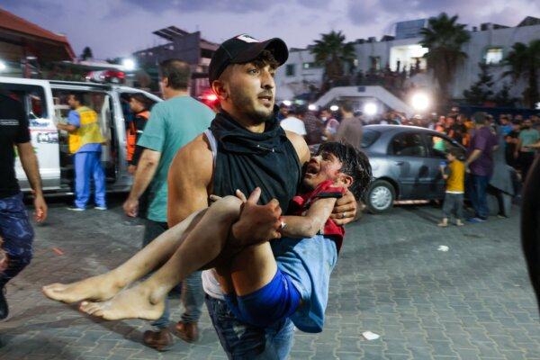 A man carries a child into Al-Shifa hospital in Gaza City on Oct. 11, 2023. (Mohammed Abed/AFP via Getty Images)