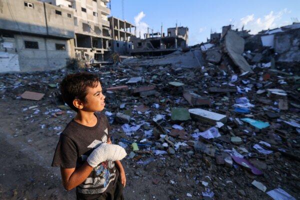 A wounded Palestinian boy, 12-year-old Mohammed Sofi, looks at buildings destroyed during Israeli airstrikes near his home in the Rafah refugee camp in the southern part of the Gaza Strip on Oct. 16, 2023. (Mohammed Abed/AFP via Getty Images)