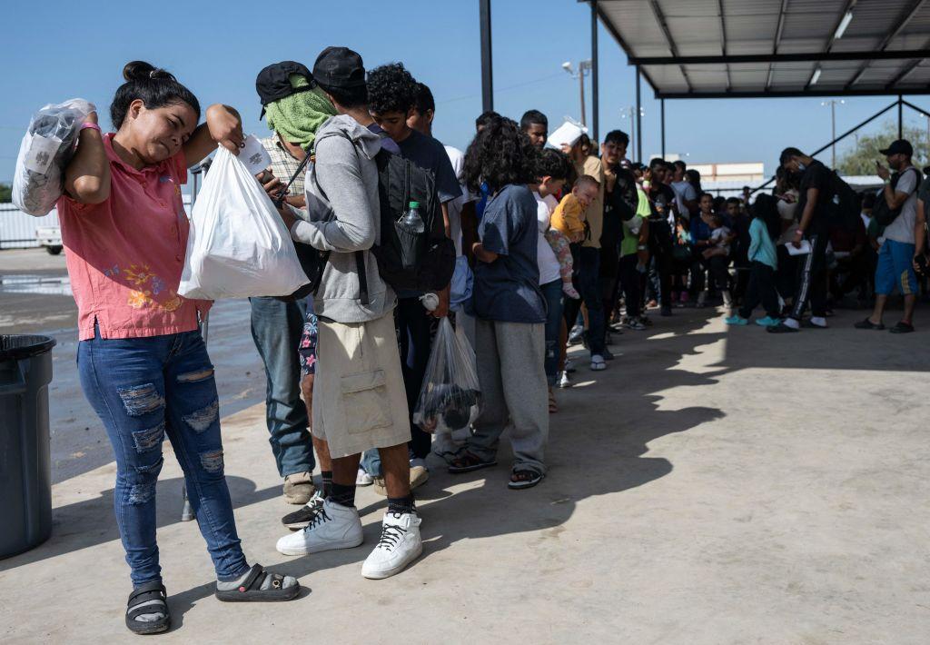 Immigrants line up as they wait for a bus to Chicago at the NGO Mission Border Hope's complex to transport them out of Eagle Pass, Texas, on Sept. 26, 2023. (Andrew Caballero-Reynolds/AFP via Getty Images)