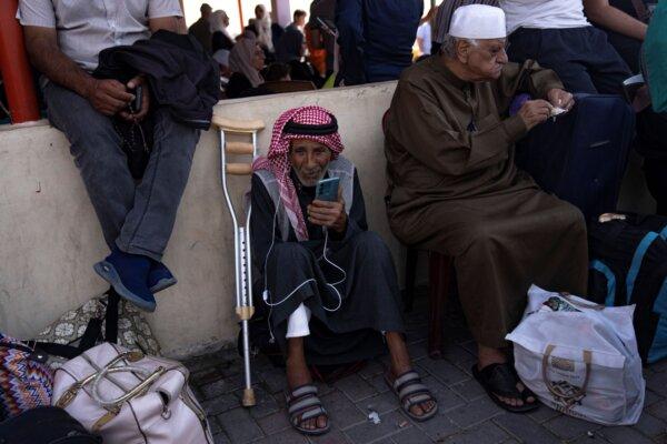 Palestinians wait to cross into Egypt at the Rafah border crossing in the Gaza Strip, on Oct.16, 2023. (Fatima Shbair/AP)