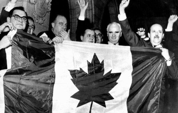 Liberal MPs hold up the single red maple leaf flag as they cheer and sing "O Canada" on Feb. 19, 1965, following a stormy session in the House of Commons in which the new flag was adopted in December 1964. (CP Photo)