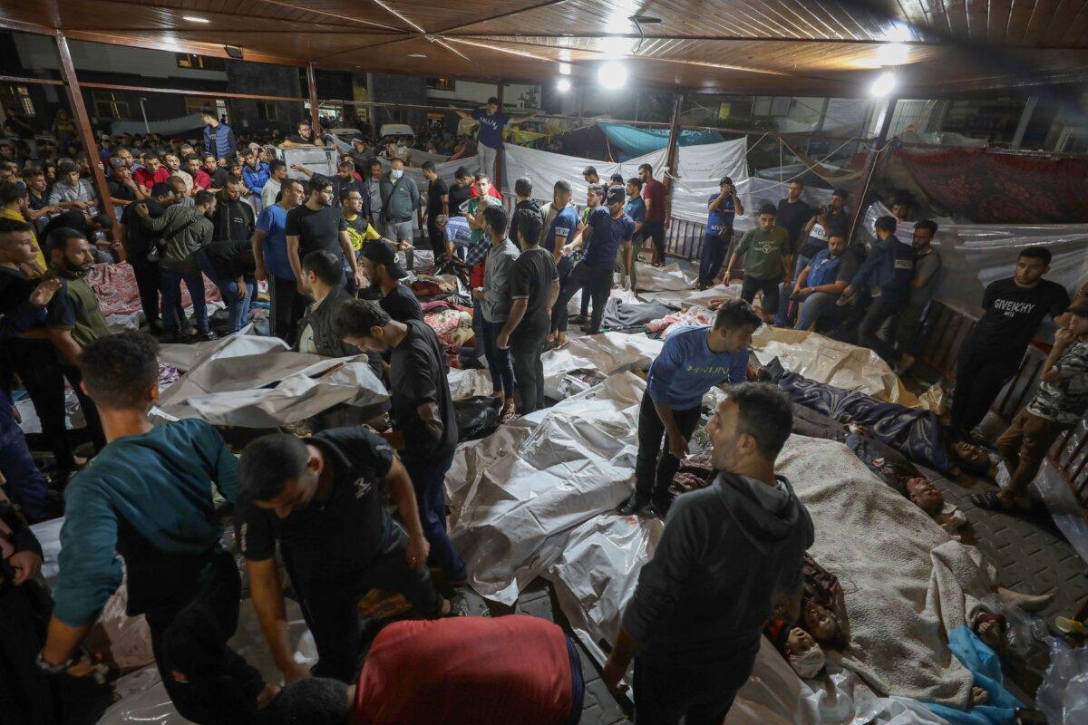 People gather around bodies of Palestinians killed in an explosion at the Ahli Arab hospital in central Gaza after they were transported to Al-Shifa hopsital, on Oct. 17, 2023. (Dawood Nemer/AFP via Getty Images)
