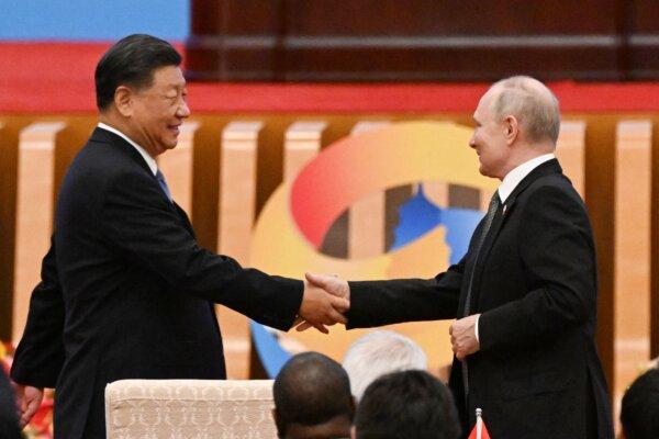 Chinese leader Xi Jinping (L) shakes hands with Russian President Vladimir Putin during the opening ceremony of the third Belt and Road Forum for International Cooperation at the Great Hall of the People in Beijing on Oct. 18, 2023. (Pedro Pardo/AFP via Getty Images)