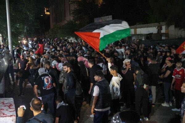 Protesters wave Palestinian flags during a rally at the entrance of the French embassy complex in Beirut early on Oct. 18, 2023. (Anwar Amro/AFP via Getty Images)