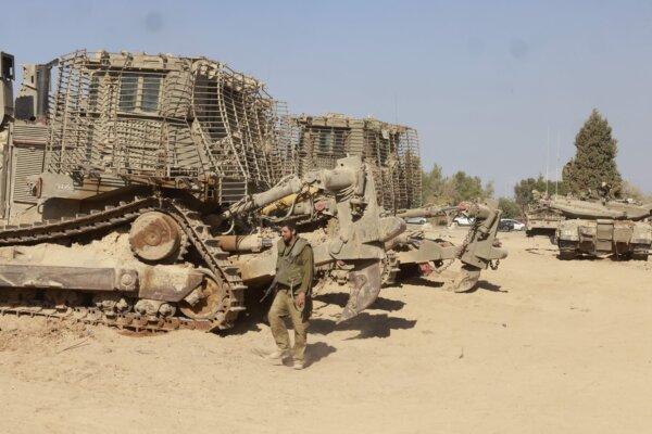 An Israeli soldier walks past army bulldozers deployed near the border with Gaza on Oct. 17, 2023. (Menahem Kahana/AFP via Getty Images)