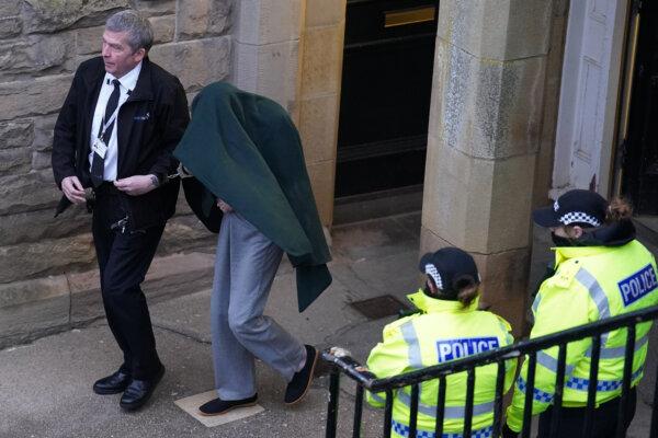 Andrew Miller (covered) is led from Selkirk Sheriff Court in Selkirk, Scotland, on Feb. 9, 2023. (Andrew Milligan/PA)