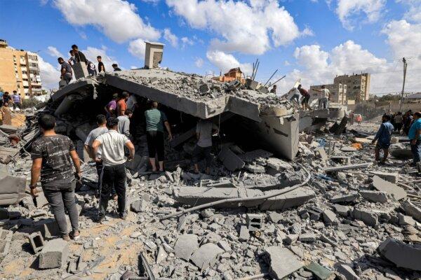 People inspect the remains of a destroyed building in Gaza on Oct. 18, 2023. (Mahmud Hams/AFP via Getty Images)