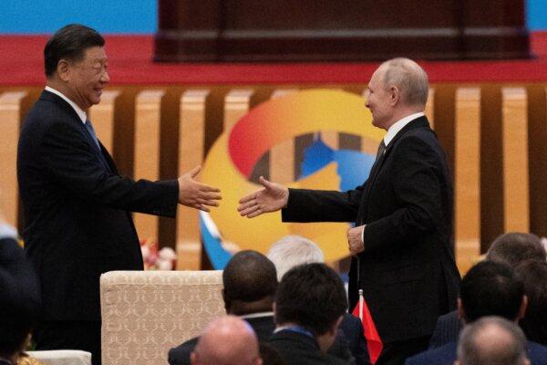 Chinese leader Xi Jinping (L) shakes hands with Russian President Vladimir Putin during the opening ceremony of the third Belt and Road Forum for International Cooperation at the Great Hall of the People in Beijing on Oct. 18, 2023. (Pedro Pardo/AFP via Getty Images)
