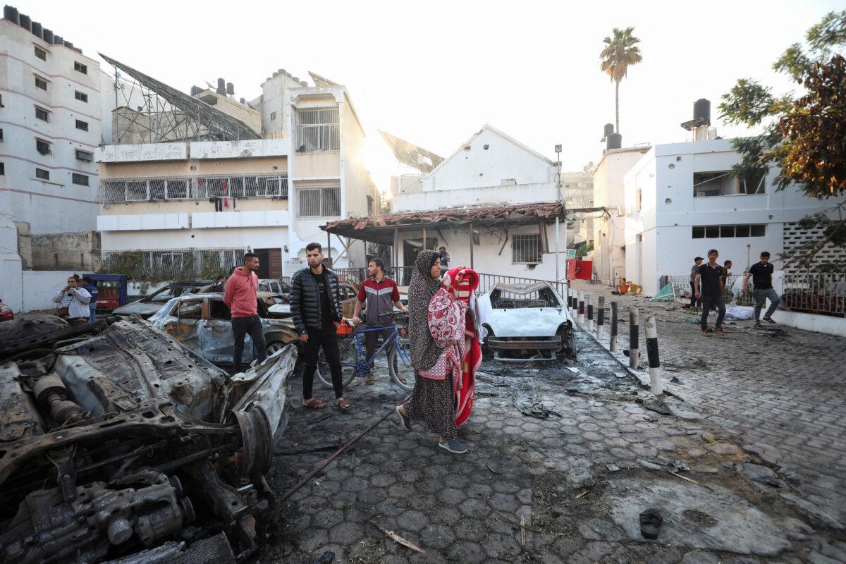 People inspect the area of Al-Ahli hospital in Gaza City, on Oct. 18, 2023, after a blast the previous day. (Mohammed Al-Masri/Reuters)