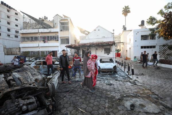 People inspect the area of Al-Ahli Hospital in Gaza City, on Oct. 18, 2023. (Mohammed Al-Masri/Reuters)