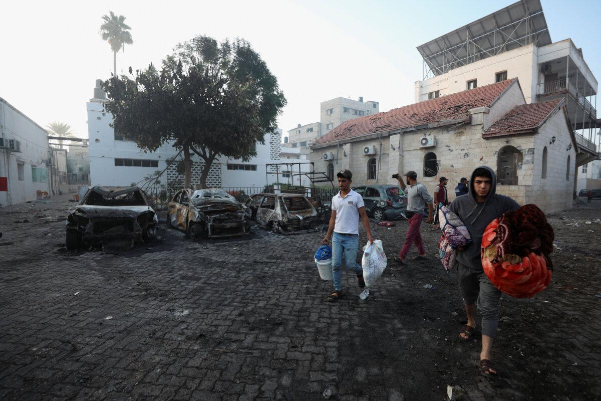 People inspect the area of Al-Ahli Hospital where an explosion took place a day earlier in Gaza City, on Oct. 18, 2023. (Mohammed Al-Masri/Reuters)