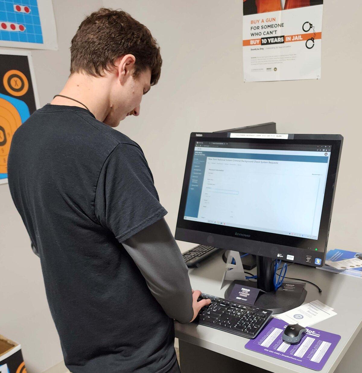 An employee of Just Holster It, a firearms store and training center in Elma, N.Y., enters information into a state background check system for an ammunition customer on Oct. 18, 2023. (Courtesy of Josh Hawkins)