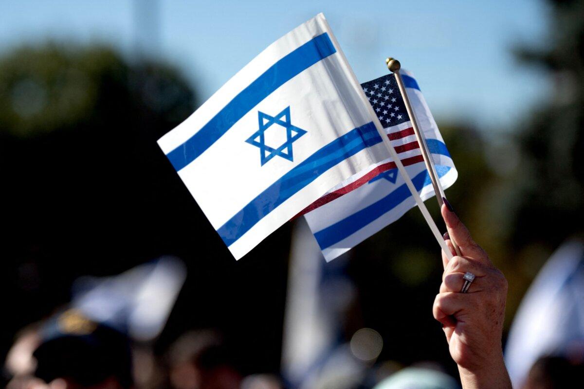 A demonstrator holds up the flags of Israel and the United States during a rally in support of Israel outside the Colorado State Capitol Building in Denver, Colo., on Oct. 15, 2023. (Jason Connolly/AFP via Getty Images)