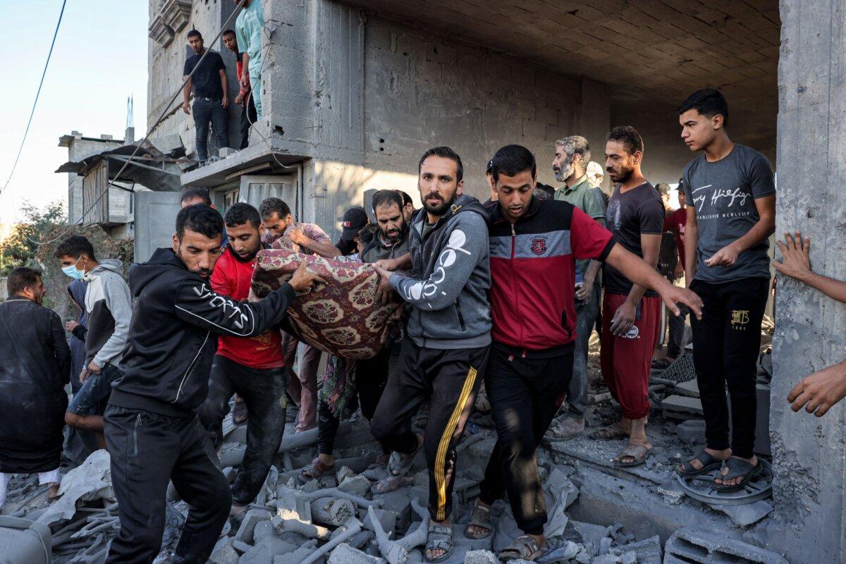 Men carry on a mattress the body of a victim killed in Israeli bombardment after it was rescued from a building in Rafah in the southern of Gaza Strip on Oct. 19, 2023. (Mohammed Abed/AFP via Getty Images)