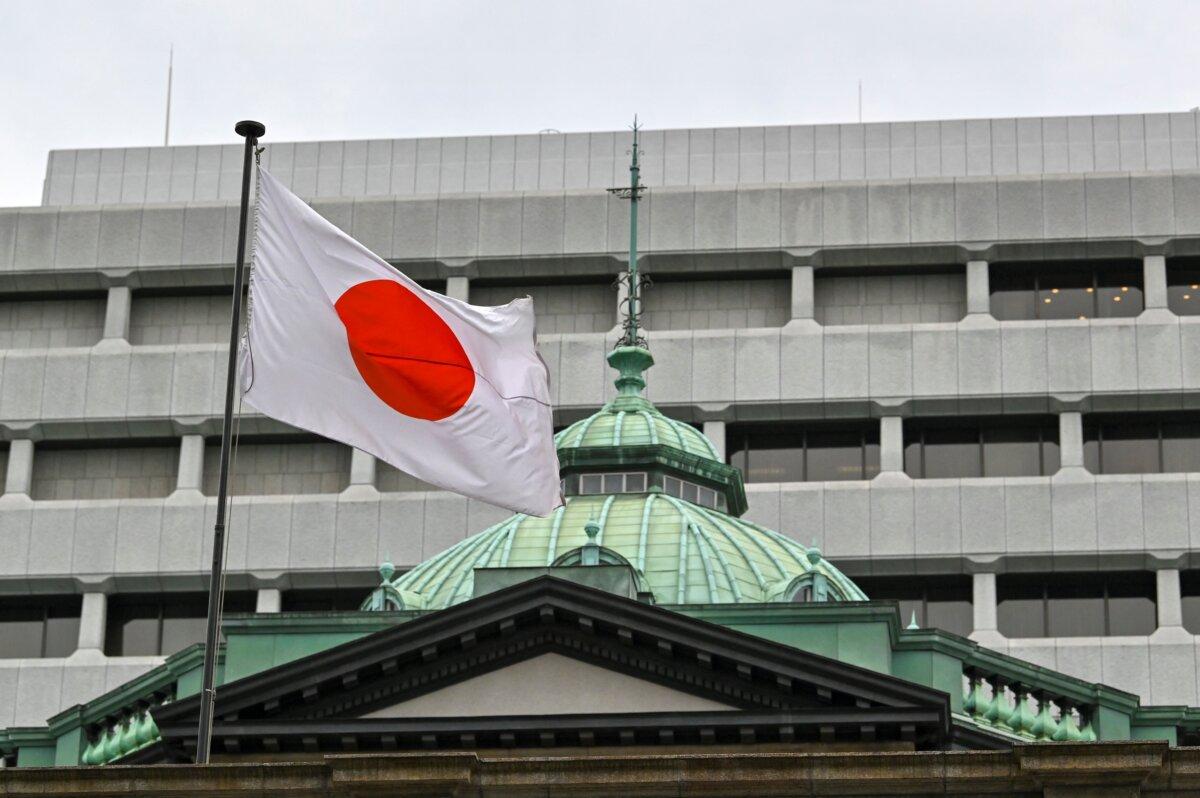 The Japanese flag flutters over the Bank of Japan head office building (bottom) in Tokyo on April 27, 2022. (Kazuhiro Nogi/AFP via Getty Images)