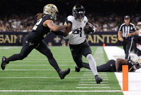Travis Etienne Jr. (1) of the Jacksonville Jaguars scores a rushing touchdown during the second quarter as Tyrann Mathieu (32) of the New Orleans Saints is unable to make the tackle at Caesars Superdome in New Orleans on Oct. 19, 2023. (Jonathan Bachman/Getty Images)