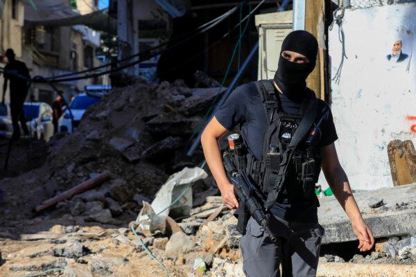 An armed Palestinian man walks amid the rubble of a building damaged during a raid by Israeli troops at the Nur Shams refugee camp near the northern city of Tulkarm in the West Bank on Oct. 20, 2023. (Zain Jaafar/AFP via Getty Images)