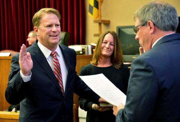 Washington County Circuit Court Clerk Kevin Tucker (R) swears in Andrew F. Wilkinson as a circuit court judge as Wilkinson's wife Stephanie watches, on Jan. 10, 2020. (Julie E. Greene/The Herald-Mail via AP)