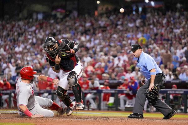Philadelphia Phillies' Kyle Schwarber is safe at home past Arizona Diamondbacks catcher Gabriel Moreno on a hit by Alec Bohm during the sixth inning in Game 4 of the baseball NL Championship Series in Phoenix on Oct. 20, 2023. (Brynn Anderson/AP Photo)