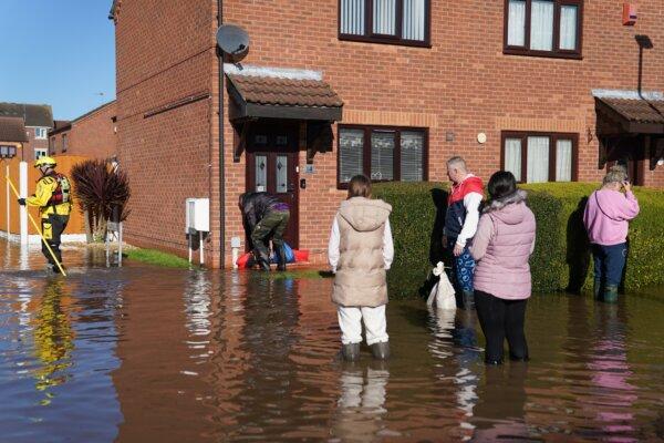 After Storm Babet battered the UK, residents walk through flood water in Retford in Nottinghamshire, England, on Oct. 22, 2023. (Joe Giddens/PA Wire)