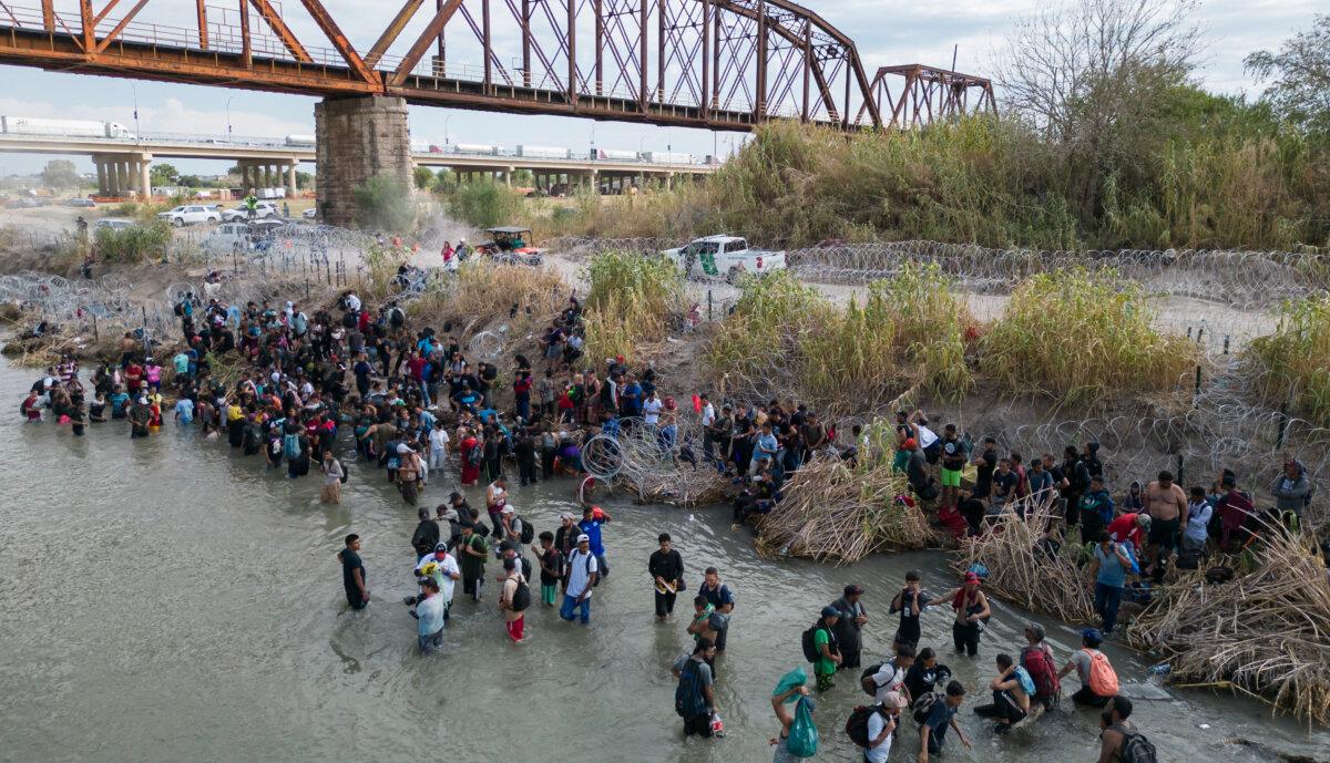 Migrants wait in the Rio Grande for an opening in the razor wire barrier, to cross into the United States, in Eagle Pass, Texas, on Sept. 25, 2023. (Andrew Caballero-Reynolds/AFP via Getty Images)