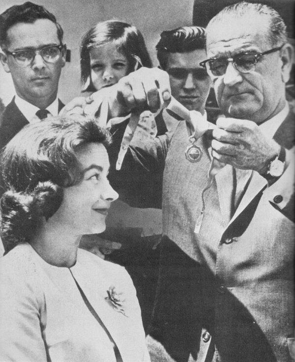 A 1964 press photo of President Johnson awarding pilot Jerrie Mock with a gold medal. (Public Domain)