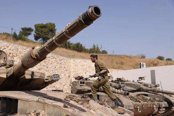 An Israeli soldier walks on a Merkava tank at a position in an undisclosed location on the border with Lebanon on Oct. 22, 2023. Lebanon's Iran-backed Hezbollah and allied Palestinian factions have traded cross-border fire with Israel for days, after Hamas gunmen attacked communities in southern Israel on Oct. 7. (JALAA MAREY/AFP via Getty Images)