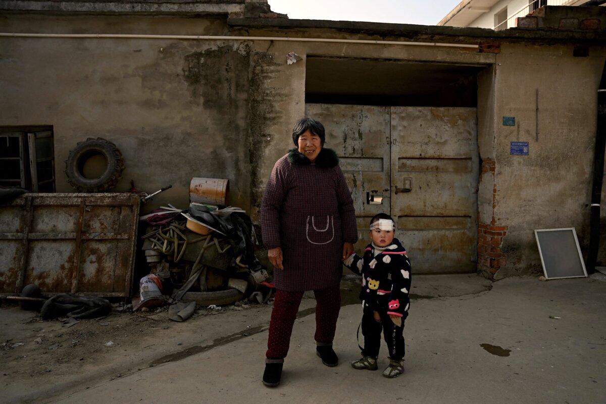 A woman and a boy stand on a street in Fengyang county in east China's Anhui Province on Jan. 5, 2023. (Noel Celis/AFP via Getty Images)
