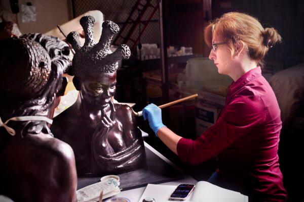 Conservation assistant Allison Cassidy restores Malvina Hoffman’s sculpture of a Sudanese woman. (Field Museum)