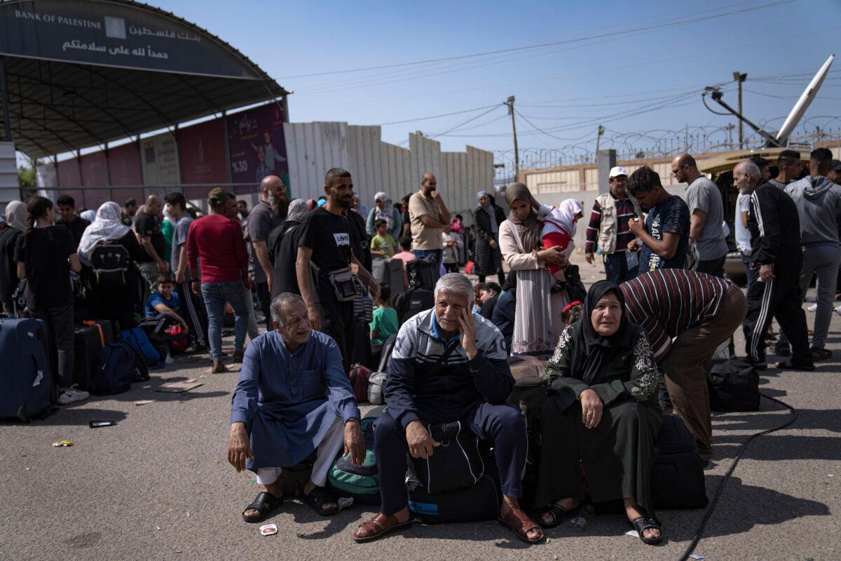 Palestinians wait to cross into Egypt at the Rafah border crossing in the Gaza Strip on Oct.16, 2023. (Fatima Shbair/AP Photo)