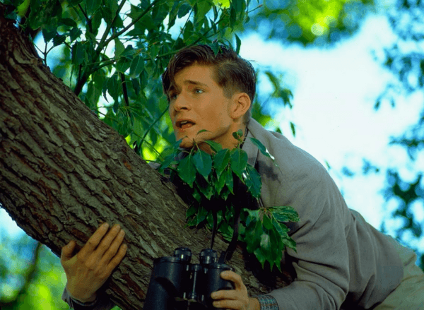 George McFly giving in to temptation and trying oggle a bare-naked lady with some binoculars, not realizing his disgusted future son has caught him in the act of being a peeping Tom, in "Back to the Future." (Universal Pictures)