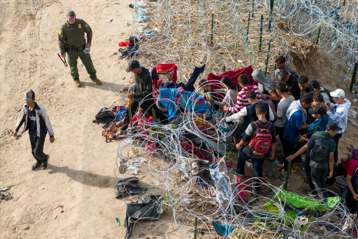 As seen from an aerial view a U.S. Border Patrol agent supervises as immigrants walk into the United States after crossing the Rio Grande from Mexico on Sept. 30, 2023 in Eagle Pass, Texas. (John Moore/Getty Images)