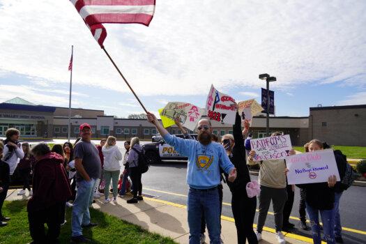 Joe Dychala, a 1990 Sun Valley Graduate, held a national flag during the walkout at Sun Valley High School on Oct. 25, 2023. (William Huang/The Epoch Times)
